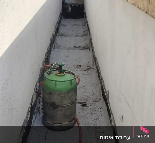 בלון גז ירוק וצינור על גג לאיטום